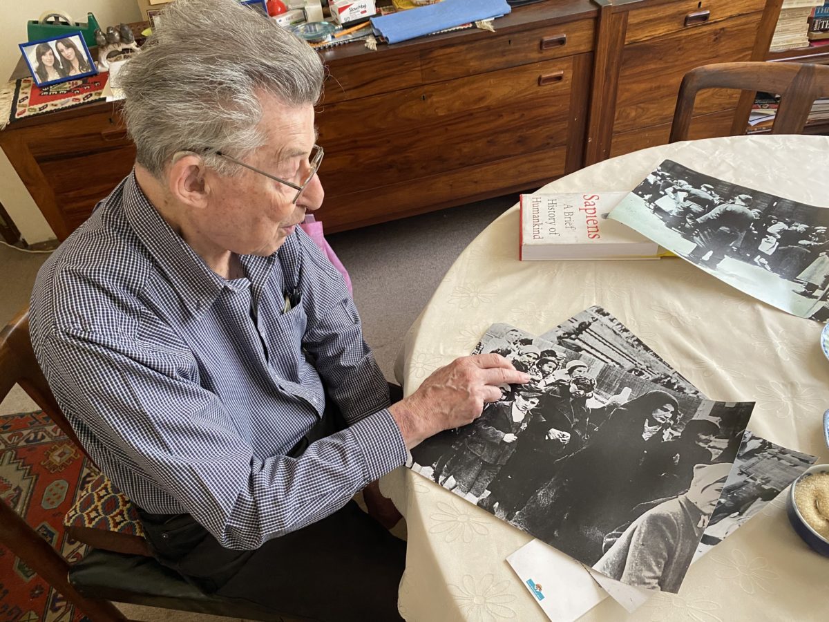 Concentration camp survivor Don Krausz points to a picture of woman holding a baby about to be sent to the gas chambers and certain death